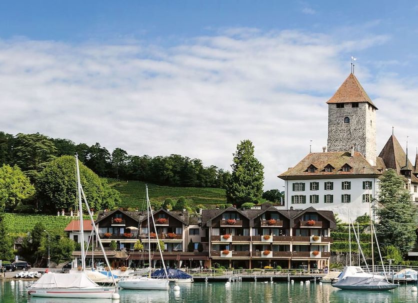 Hotel-Restaurant Seegarten-Marina in Spiez with lakeside chalets, sailboats and a castle tower