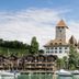 Hotel-Restaurant Seegarten-Marina in Spiez with lakeside chalets, sailboats and a castle tower