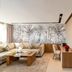 Kenzi Rissani in Errachidia living room with beige sectional sofa, wood coffee table, desk and tropical mural