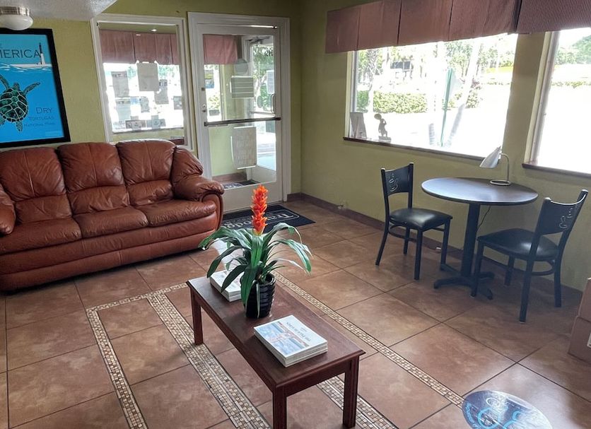 Motel 6 Riviera Beach lobby with sofa, table, chairs, and large windows