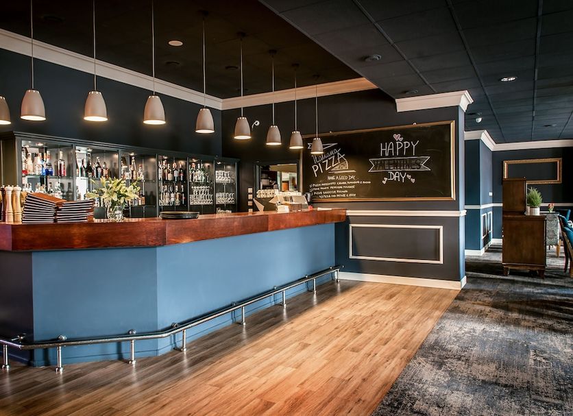 Hotel IOR in Poznan bar area with wood counter, pendant lights, chalkboard menu and lounge seating