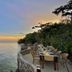 Magic Oceans Dive Resort in Anda: seaside dining terrace with tables beside calm ocean at sunset