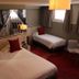 La Confiance in Le Mont-Saint-Michel guest room with double bed and single bed, red accents, and window