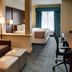 Comfort Suites Texarkana guest room with king bed, desk, seating area and window with curtains