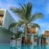 Arugambay Roccos in Arugam with palm trees and modern villas by a blue pool under clear sky
