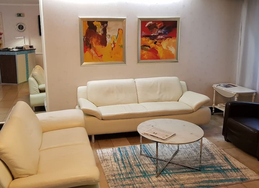 Wald-Hotel Troisdorf lobby lounge with cream sofas, round coffee table, and abstract wall art