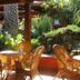 Th Costa Rei - Free Beach Resort in Costa Rei, outdoor wicker seating under a shaded patio with lush tropical plants.