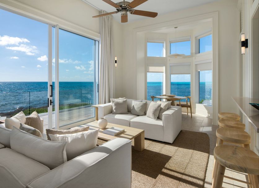 Ambergris Cay Private Island living room with floor-to-ceiling ocean views in Big Ambergris Cay