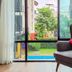 Chiang Mai Thai House in Chiang Mai with a wingback chair by a window overlooking greenery and a pool