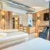 Hotel Leipziger Hof Innsbruck spa room with massage beds, wood paneling and wall-mounted TVs