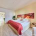 Arador City Hotel in Bad Oeynhausen bedroom with double bed, red throw, and light wood flooring