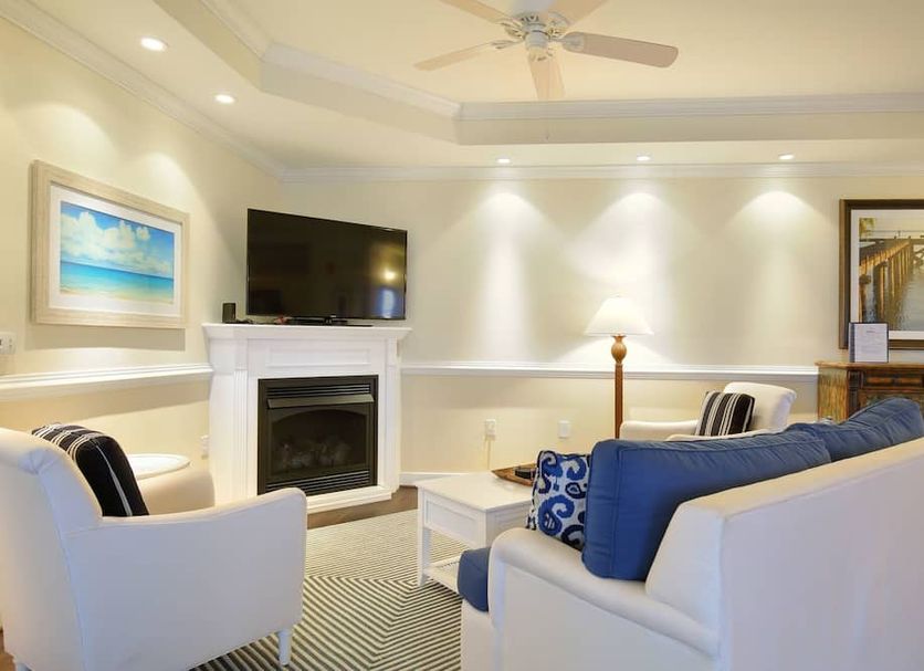 Waterside Resort in Edenton living room with fireplace, TV, and white seating