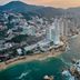 Fiesta Americana Acapulco Villas overlooking Acapulco bay, beachfront towers and rocky shoreline at sunset.