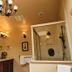 Chalet of Canandaigua bathroom with glass shower, double vanity, wall sconces and chandelier