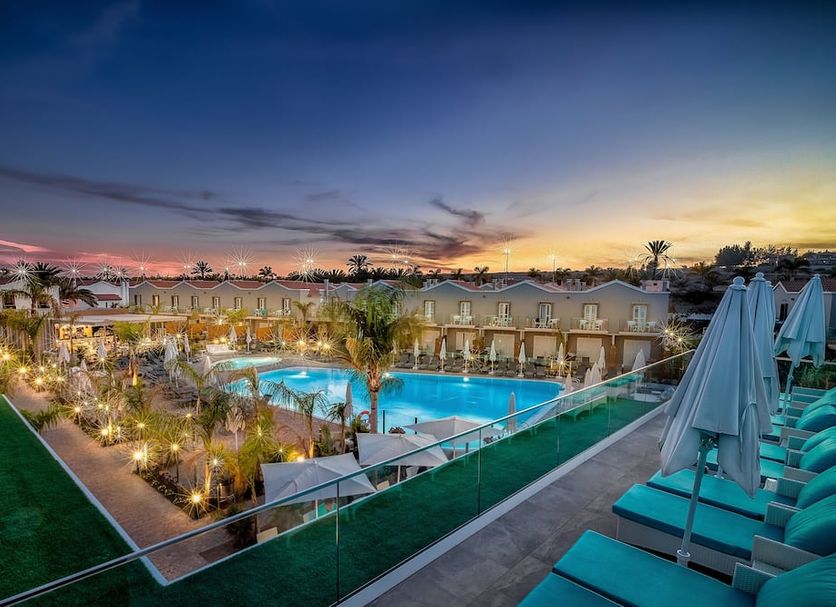 Hotel Livvo Los Calderones in Maspalomas with pool, palm-lit terrace and sunset views