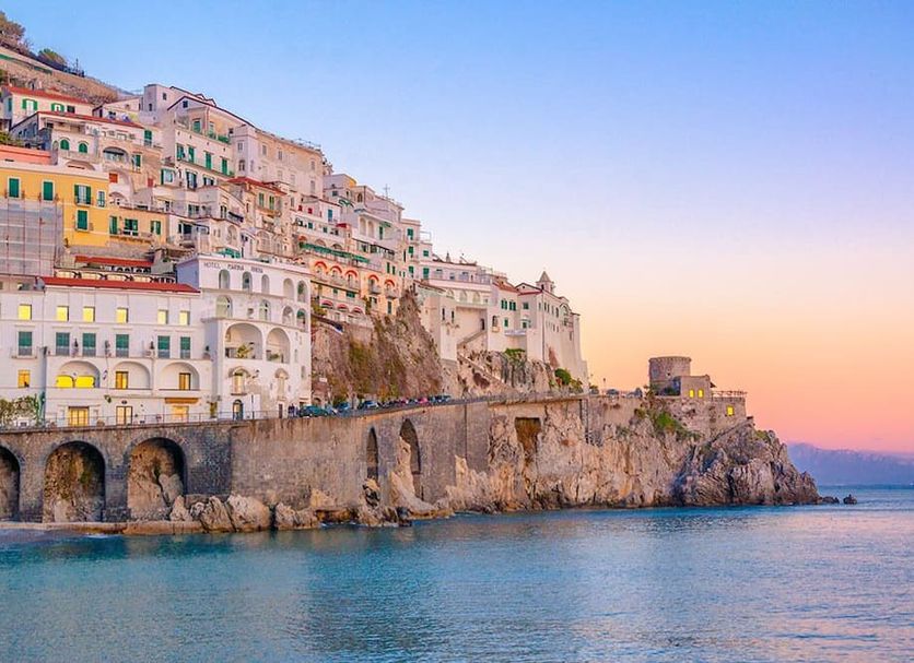Hotel Polo Nautico in Salerno with cliffside buildings and sea view at sunset