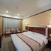 Hubin Bubugao Hotel in Qingyuan guest room with bed, chairs by window, TV and bedside lamp