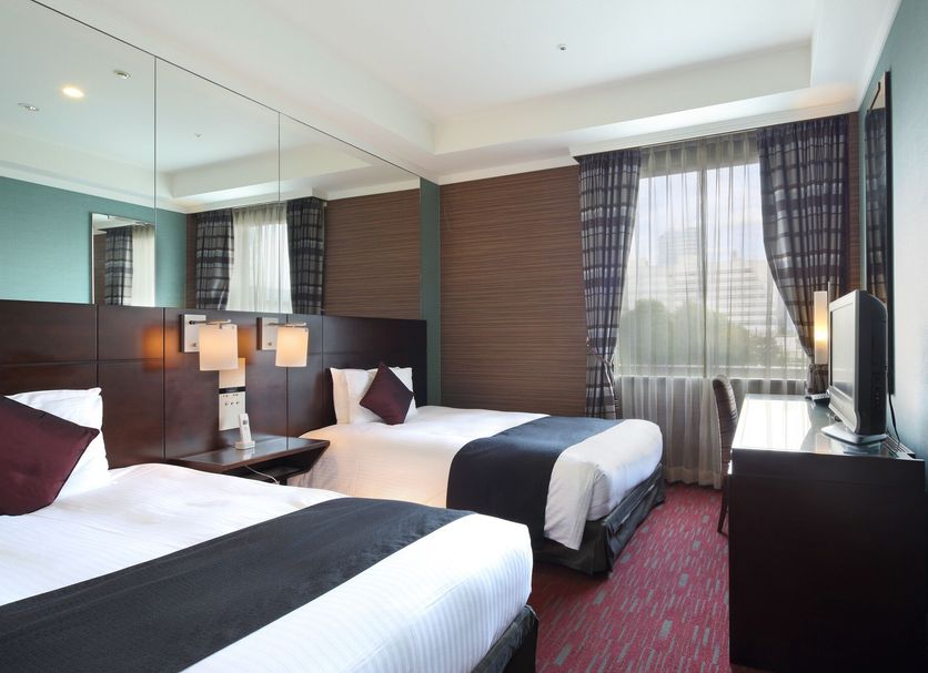 Hotel Trusty Tokyo Bayside guest room with two twin beds, large window and city view in Tokyo