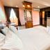 Aa Pattaya Ville, Pattaya: guest room with king bed, desk, TV, wardrobe, and balcony curtains