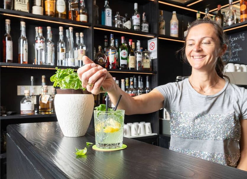 Hotel Gardenazza in Badia/Abtei bar with smiling bartender serving a cocktail