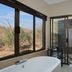 Shepherd's Tree Game Lodge, Pilanesberg: bath with large windows overlooking bush and outdoor shower.
