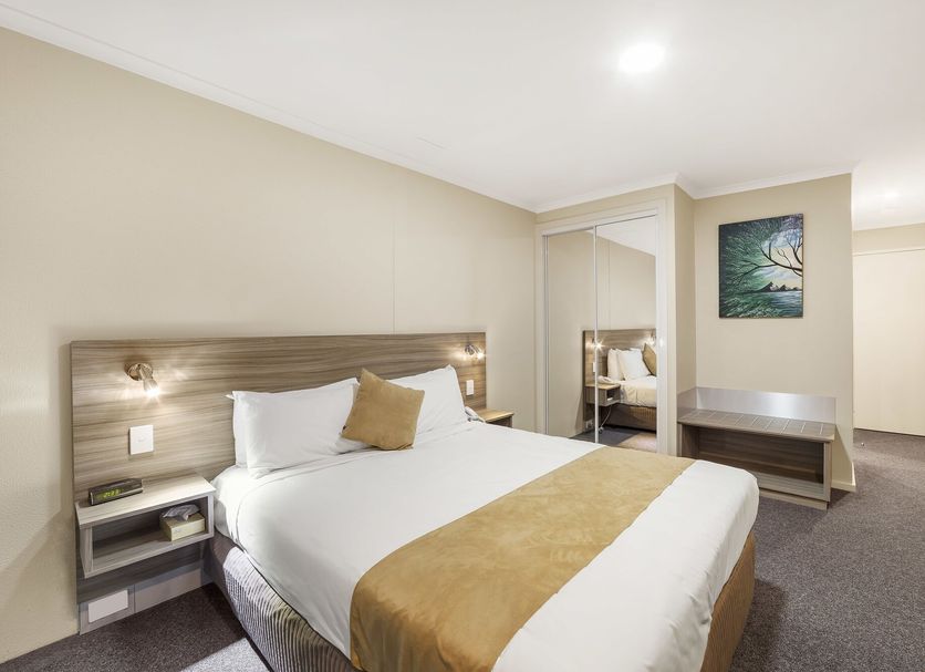 Ciloms Airport Lodge Tullamarine guest room with king bed, mirrored wardrobe and desk