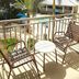 Trianon Bonita Bay Hotel in Bonita Springs balcony view of pool, palm trees and patio seating