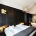 Hotel Zugbrücke Grenzau room with king bed, freestanding tub and dark wood decor in Hohr Grenzhausen