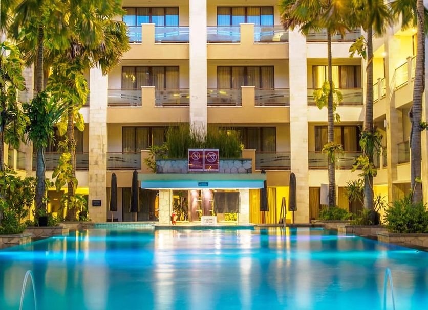 Aston Kuta Hotel & Residence in Kuta with a palm-lined outdoor pool and balcony rooms