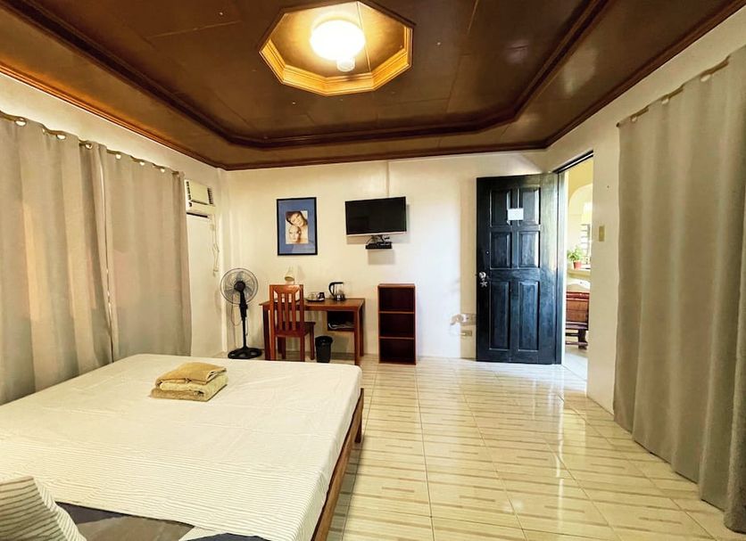 Stardust Beach Hotel Matabungkay Batangas guest room with bed, desk, TV, and tile floor in Lian