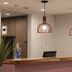 Arya Inn & Suites in Irving lobby front desk with pendant lights and potted plant