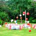 Golden Tulip Kumasi City outdoor event setup on lawn in Kumasi with white tables and red-and-white balloons
