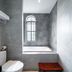 Lcs Hotel & Apartment Phnom Penh bathroom with bathtub, toilet, and arched window