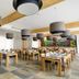 Hotel Chateau Gbelany in Gbelany dining room with wooden tables, chairs, and modern pendant lights