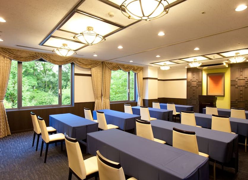 Kyoto Garden Palace meeting room in Kyoto with rows of tables, cream chairs, and large garden-view windows