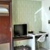 High Point Surabaya hotel room with wardrobe, TV, desk and chair in Surabaya