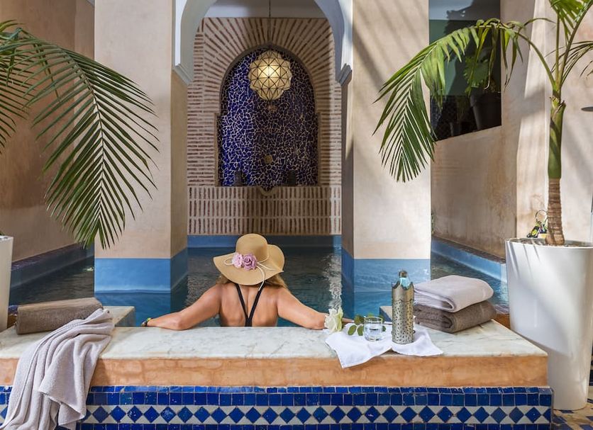 Riad Ines Home in Marrakech: small indoor pool with arched mosaic wall and potted palms