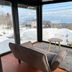 Active Life Madarao in Iiyama: cozy lounge with floor-to-ceiling windows and mountain snow view