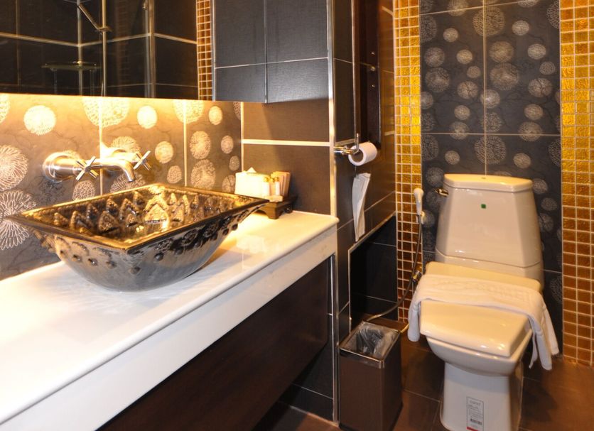 Chalelarn Hotel in Hua Hin bathroom with vessel sink, mirror, and tiled toilet area