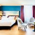 Nyx Hotel Mannheim by Leonardo Hotels room with king bed, chairs, sofa and large window in Mannheim