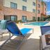 TownePlace Suites by Marriott Dallas Lewisville poolside patio with lounge chairs and outdoor pool