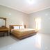 Tanjung Alam Hotel in Buleleng room with bed, vanity mirror, chair and window light