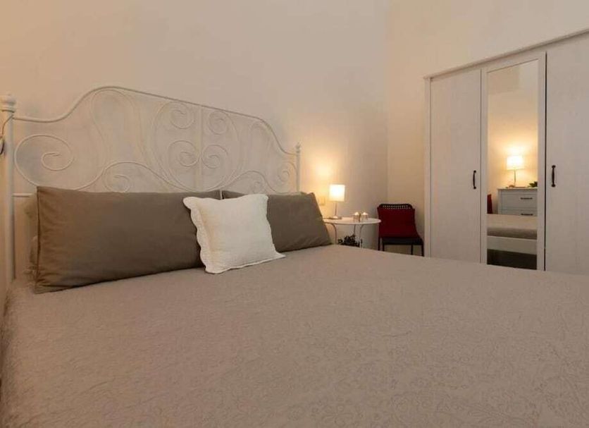 Sichelgaita Apartment in Salerno bedroom with bed, mirrored wardrobe and bedside lamp