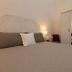 Sichelgaita Apartment in Salerno bedroom with bed, mirrored wardrobe and bedside lamp