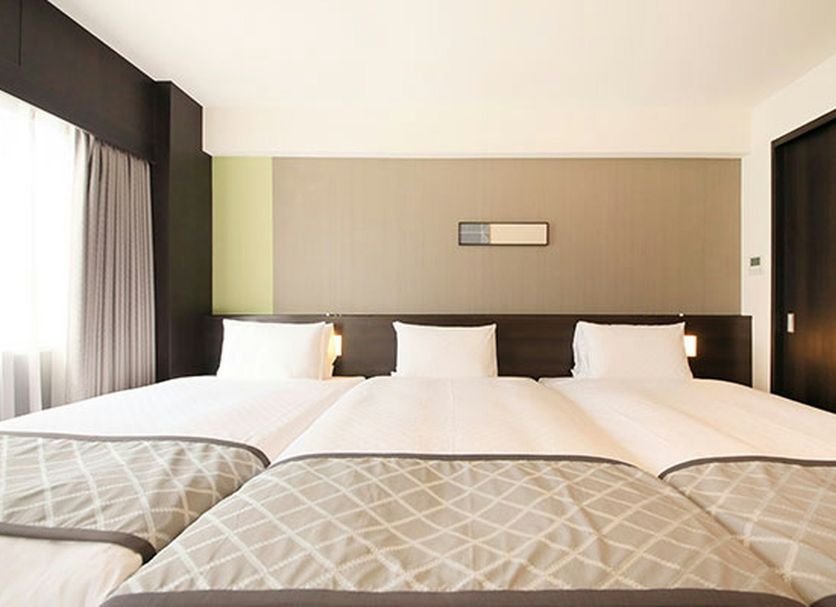 Richmond Hotel Higashi Osaka room with three beds, large window, and neutral-toned headboard in Higashiosaka