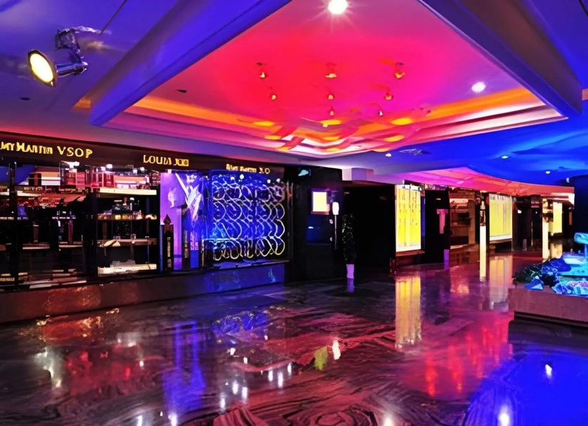 Hohhot Hai Liang Plaza Hotel lobby with neon ceiling lights, glossy marble floor, and bar seating in Hohhot