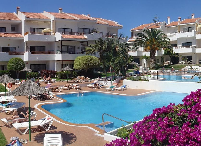 Apartamentos HG Cristian Sur in Los Cristianos with outdoor pool, sun loungers and palm trees