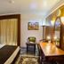 Hotel Galaxy Karachi guest room with king bed, desk, mirror and window curtains