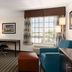 La Quinta Inn & Suites by Wyndham Bakersfield North guest room with desk, chair, window and seating area