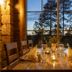 Basecamp Oulanka dining room in Kuusamo with candlelit table and forest view at dusk